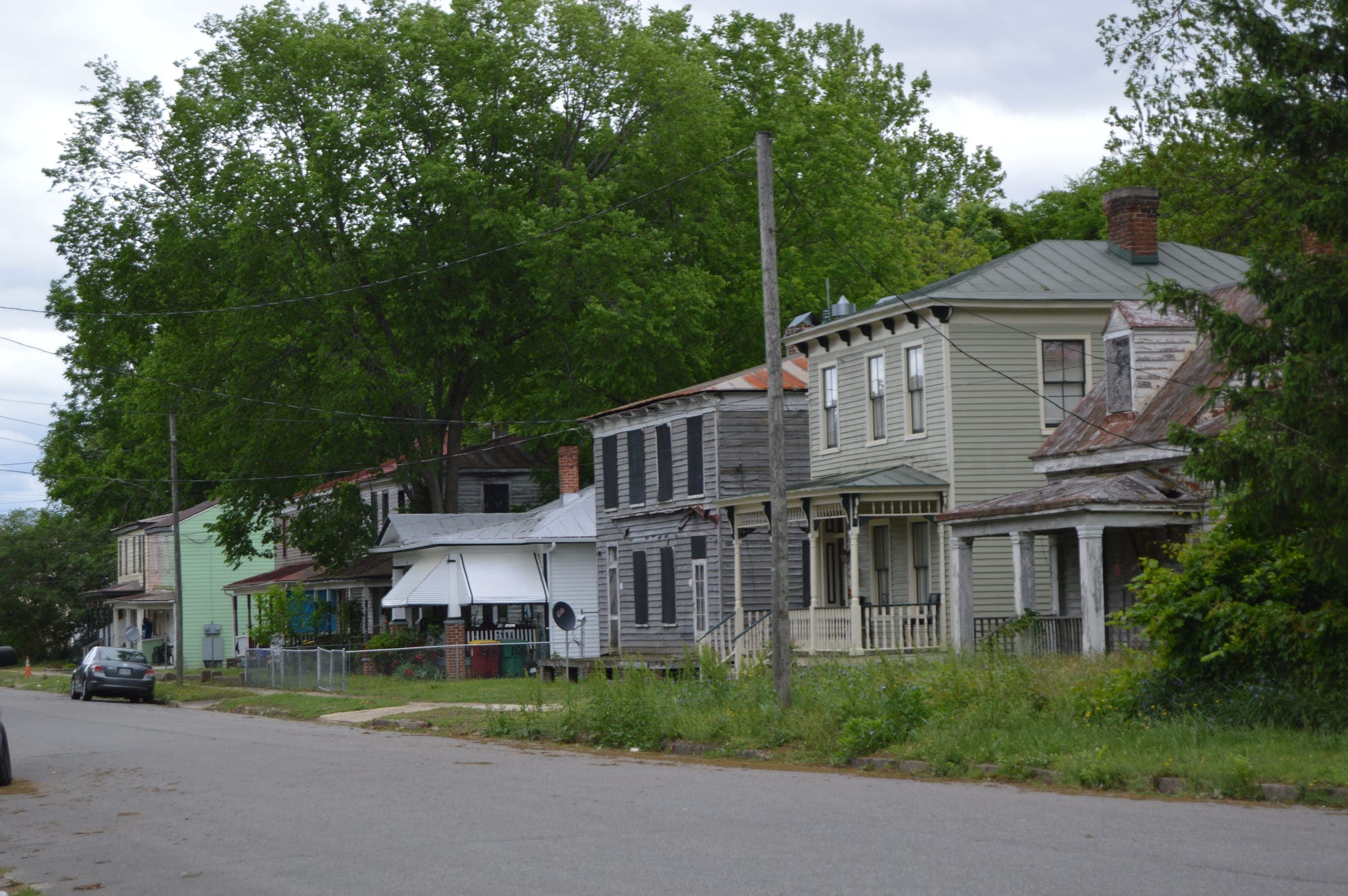 Older frame houses with front porches along a shaded street